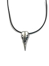 A necklace with a brushed silver bird skull pendant on a black leather cord.